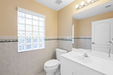 an empty room with windows and a ceiling fan