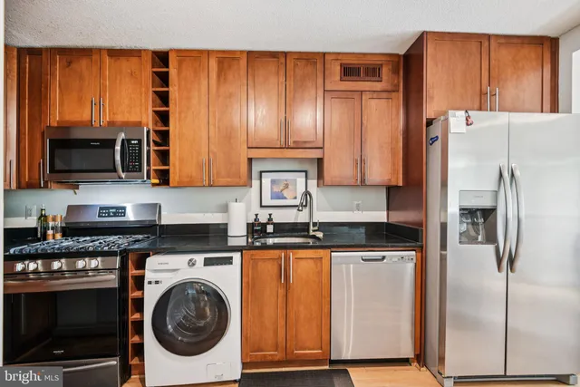 a kitchen with stainless steel appliances granite countertop a refrigerator and a stove top oven