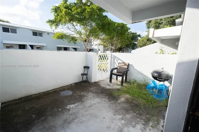 a view of backyard with outdoor seating and plants