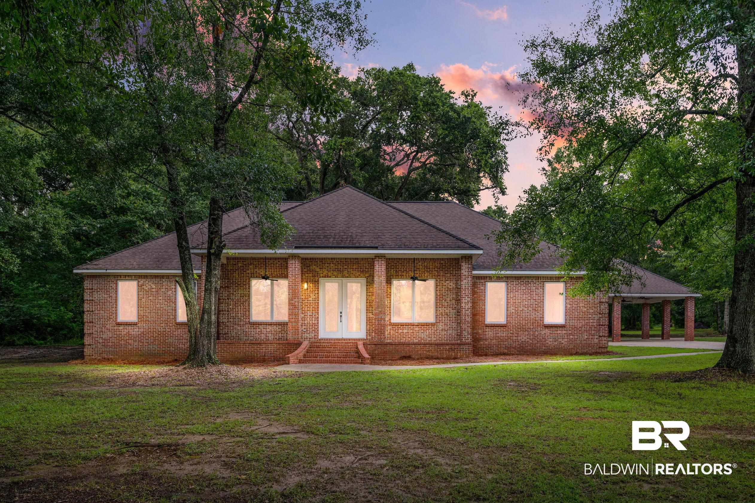15031 Timber Ridge Drive Loxley, AL 36551 - Photo 1 of 43 Back house at dusk featuring a lawn