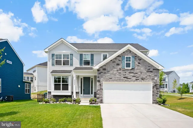 a front view of a house with a garden and yard