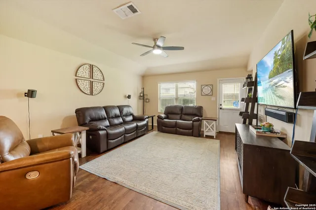 a living room with furniture wooden floor and a flat screen tv