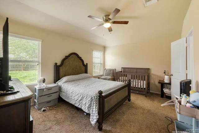 a bedroom with a bed a large window with table and chairs