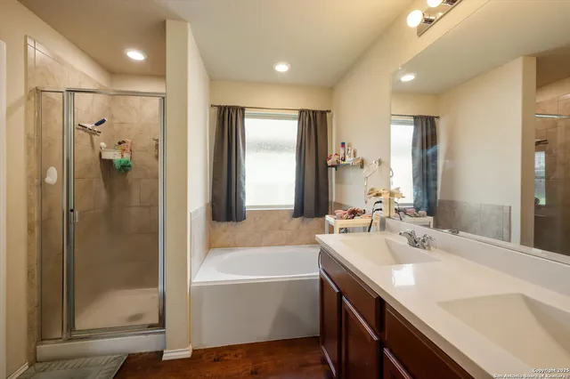 a bathroom with a tub sink shower and mirror