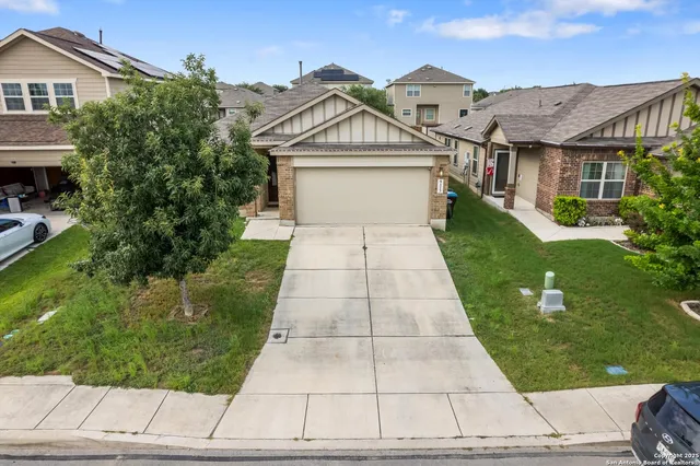a view of a white house with a small yard and plants