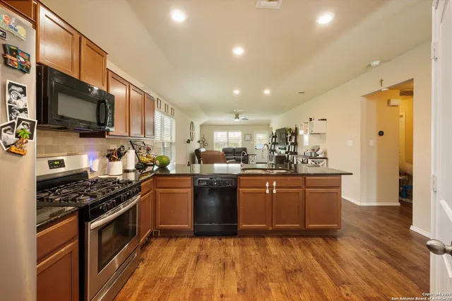 a kitchen with stainless steel appliances granite countertop a stove a sink and a refrigerator