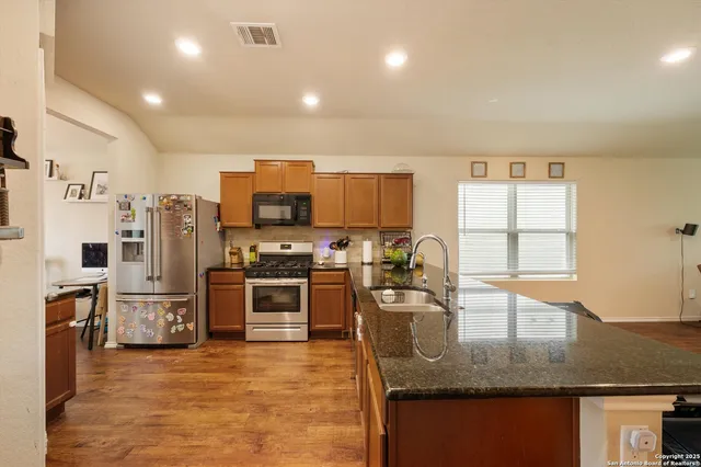 a kitchen with stainless steel appliances granite countertop a stove top oven a sink and dishwasher