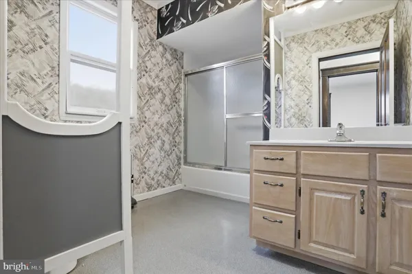 a bathroom with a sink a mirror and a shower