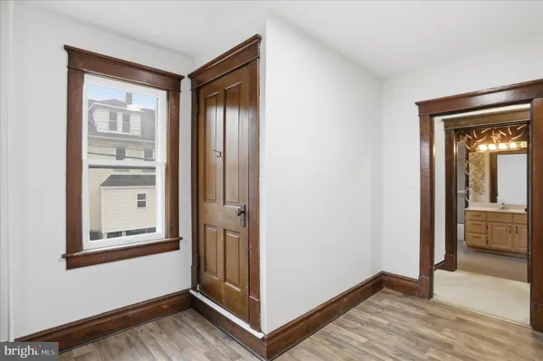 a view of a hallway with wooden floor and closet
