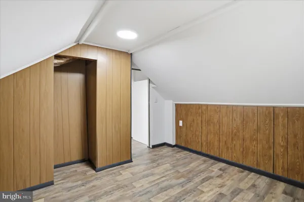 an empty room with wooden floor and closet area