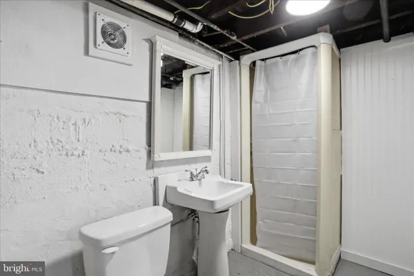 a bathroom with a sink a toilet and shower