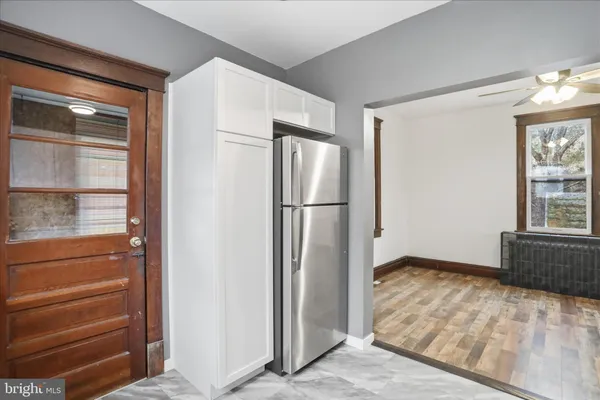 a view of empty room with windows and refrigerator