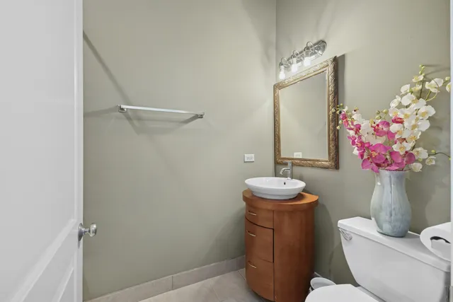 a bathroom with a toilet sink vanity granite and mirror