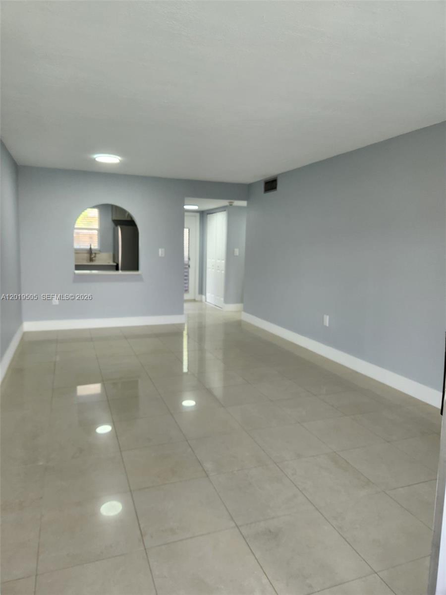 2811 North Pine Island Road, Unit 107 Sunrise, FL 33322 - Photo 6 of 16 a view of an empty room with window and wooden floor