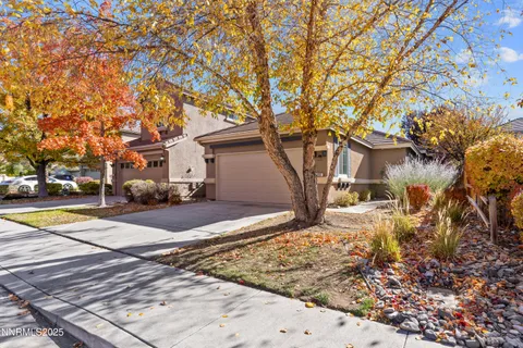 a view of a white house with a large tree next to a yard