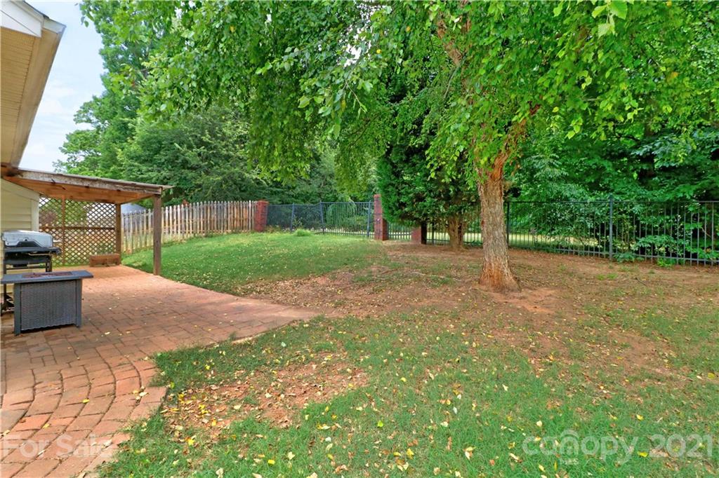 120 Cinebar Road Mooresville, NC 28115 - Photo 30 of 36 a view of a backyard with large trees and wooden fence