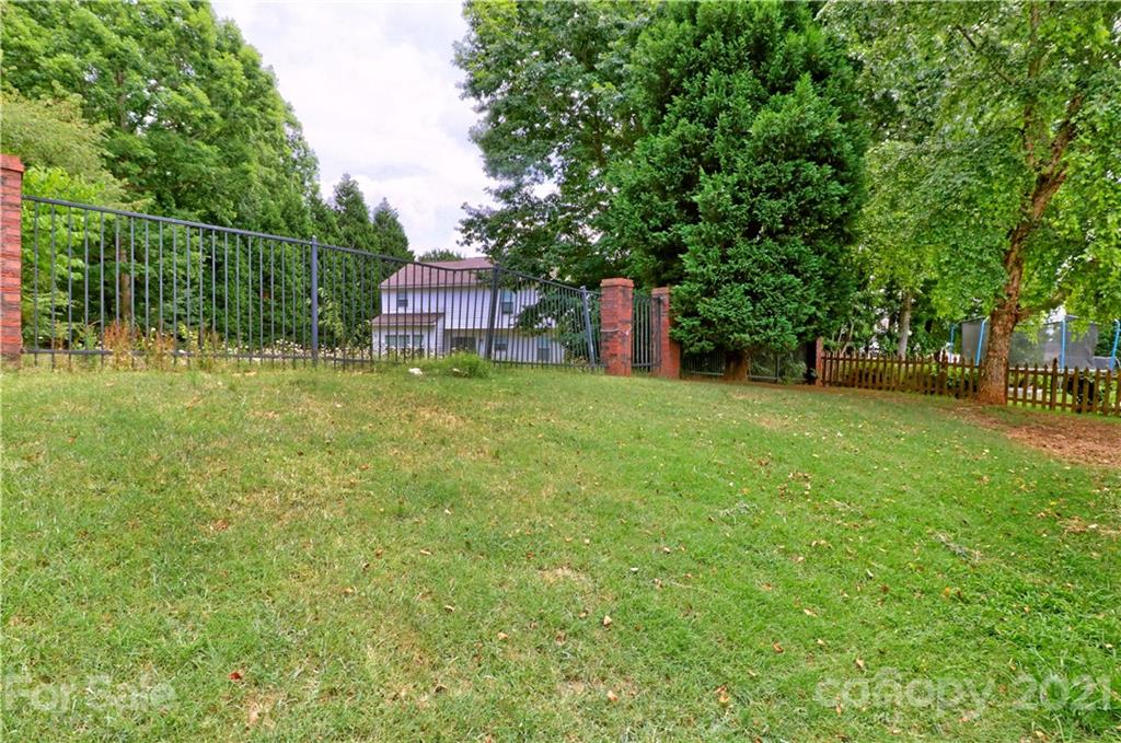 120 Cinebar Road Mooresville, NC 28115 - Photo 32 of 36 a backyard of a house with fountain plants and large tree