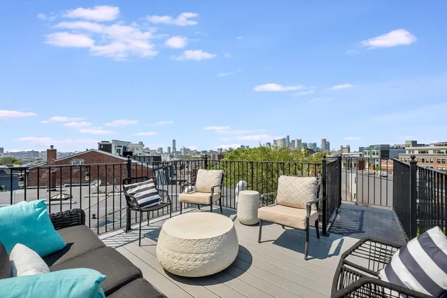 a view of a roof deck with couches and potted plants
