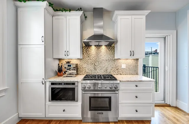 a kitchen with stainless steel appliances white cabinets and a stove