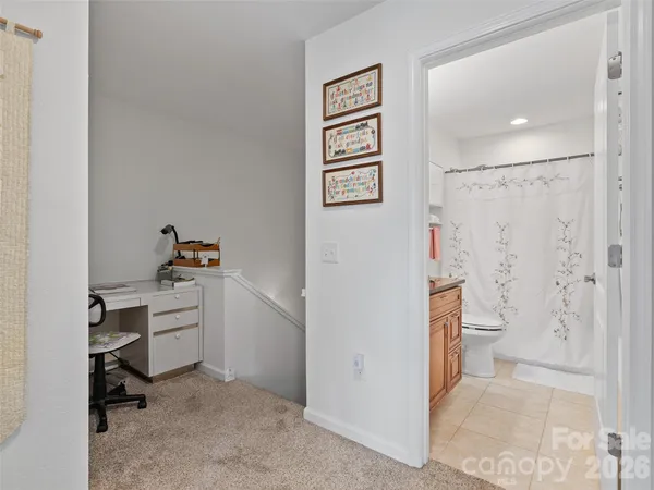 a view of kitchen with white cabinets and chair