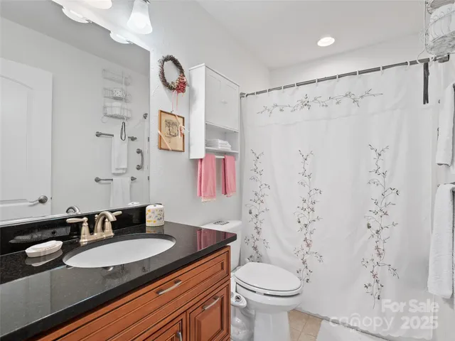 a bathroom with a granite countertop sink toilet and a mirror