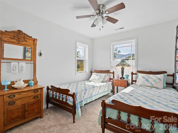 a bedroom with two beds and painting on the wall