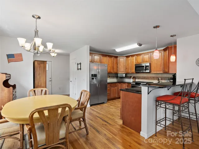 a view of a dining room with furniture a kitchen and chandelier