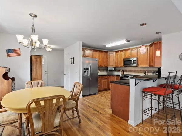 a view of a dining room with furniture a kitchen and chandelier
