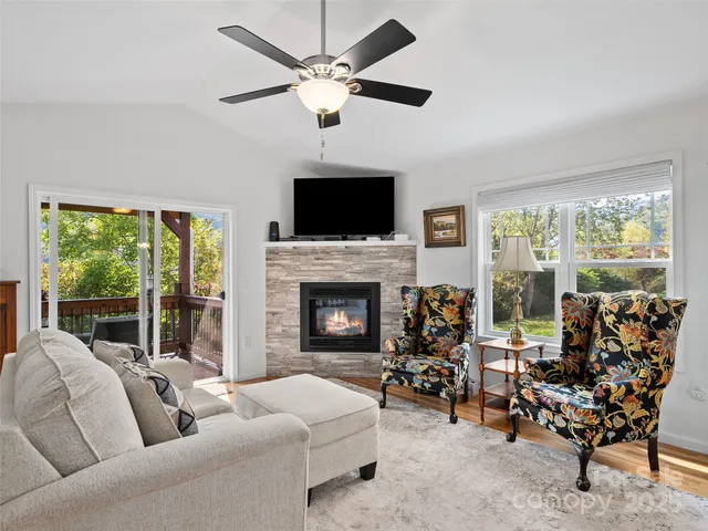 a living room with furniture large window and a fireplace