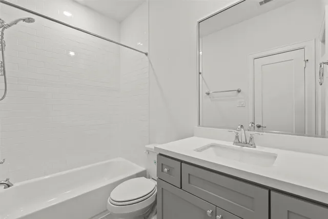 a bathroom with a granite countertop sink a toilet and shower