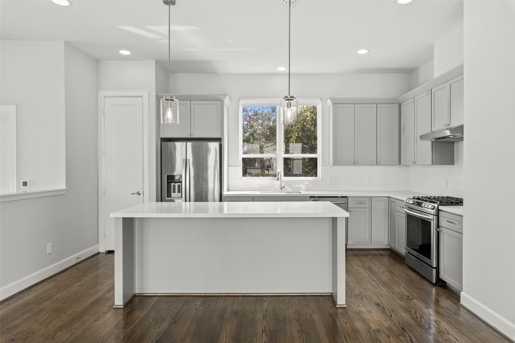 6315 Timbergrove Gardens Lane Houston, TX 77008 - Photo 16 of 33 a kitchen with stainless steel appliances granite countertop a stove a sink dishwasher a refrigerator and white cabinets with wooden floor