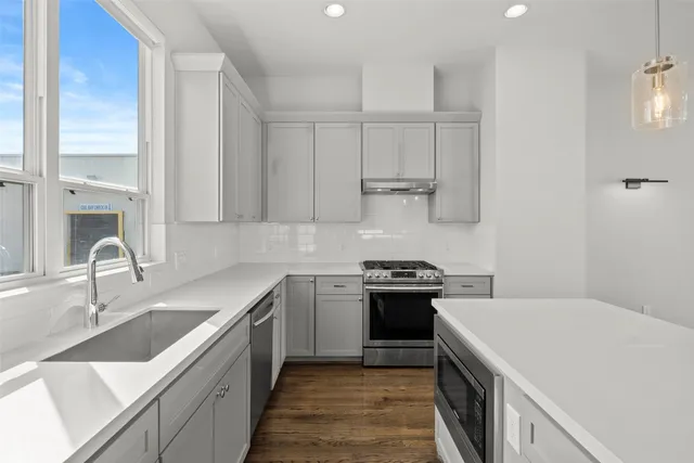 a kitchen with a sink stove and cabinets