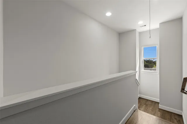 a view of an empty room with wooden floor