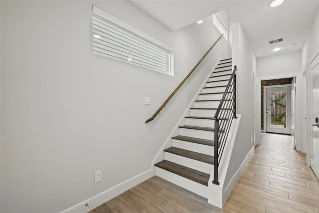 a view of a hallway with wooden floor and entryway