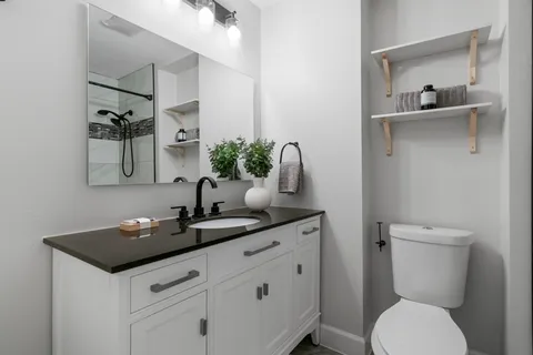 a bathroom with a toilet sink and mirror