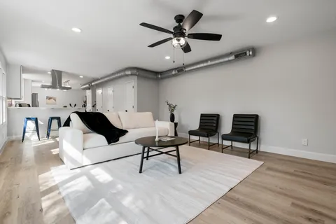 a living room with furniture and a ceiling fan