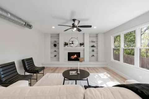 a living room with furniture a fireplace and a large window