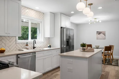 a kitchen with a sink appliances and cabinets
