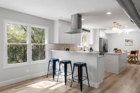 a kitchen with a table chairs sink and cabinets