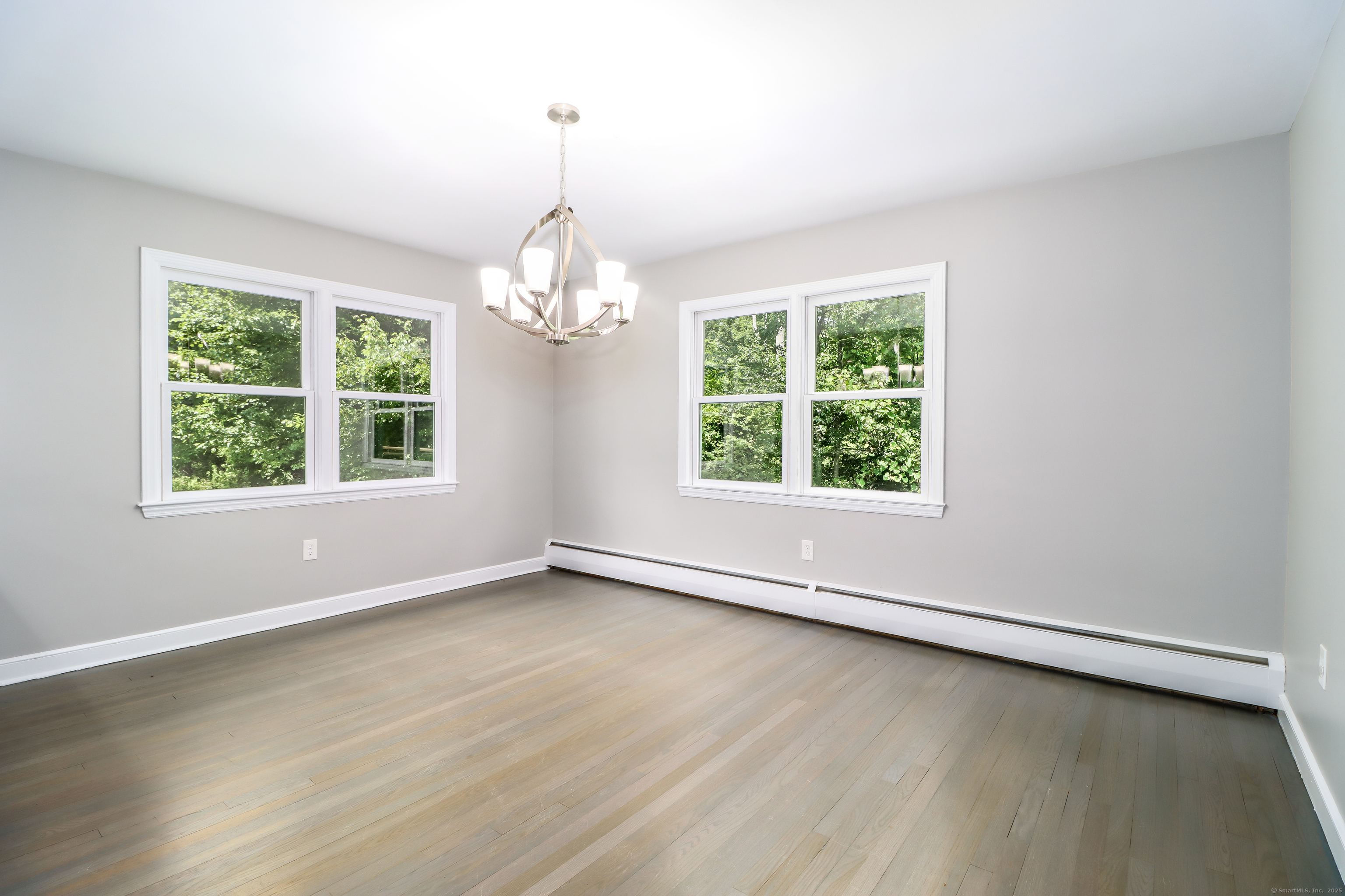 22 Lonetown Road Redding, CT 06896 - Photo 16 of 37 an empty room with wooden floor windows and a chandelier