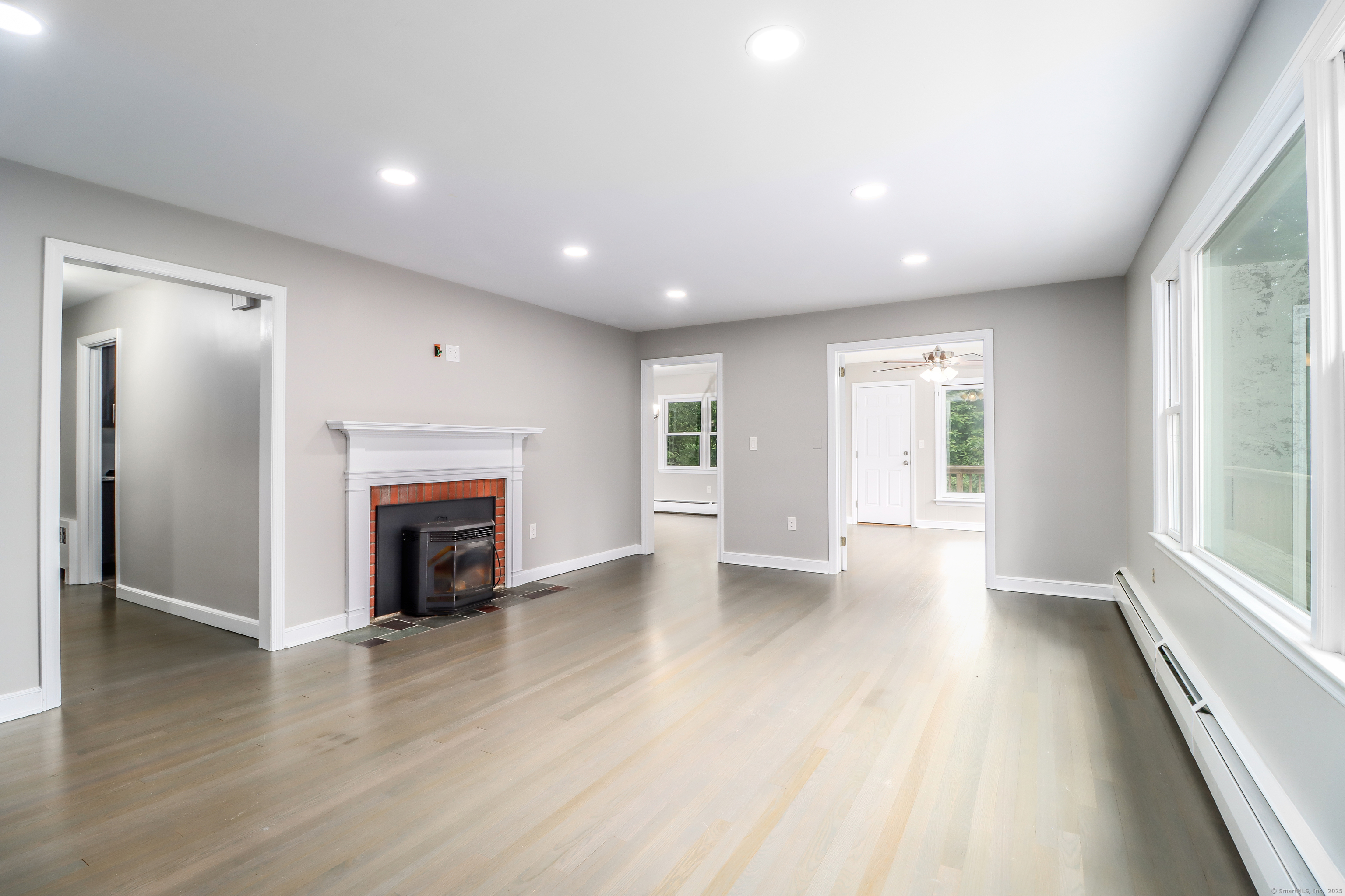 22 Lonetown Road Redding, CT 06896 - Photo 6 of 37 an empty room with wooden floor and a fireplace