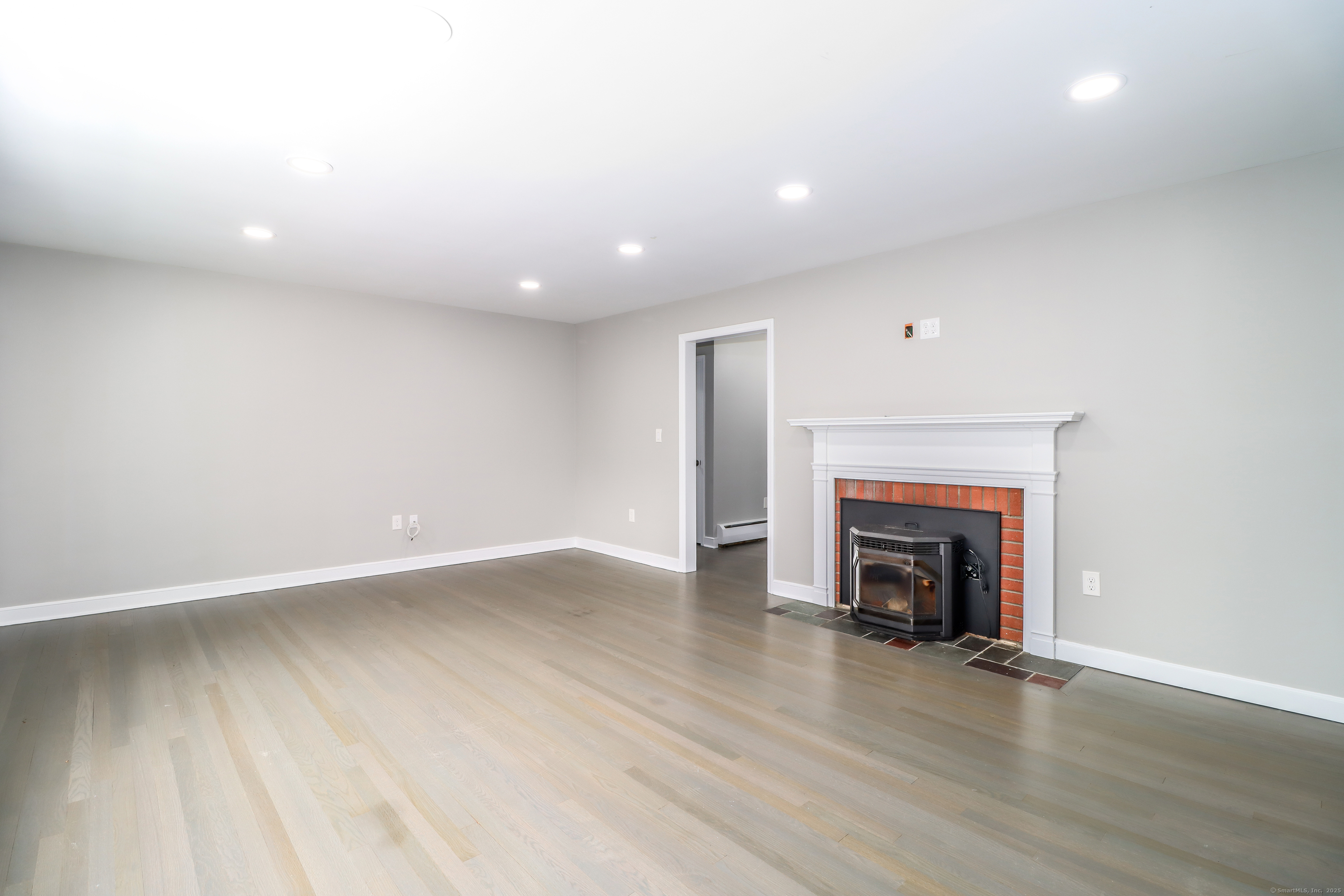 22 Lonetown Road Redding, CT 06896 - Photo 8 of 37 an empty room with wooden floor and fireplace