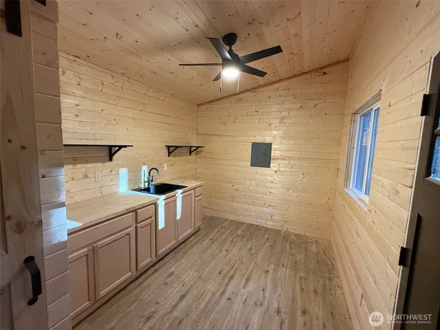 a kitchen with a sink and wooden floor
