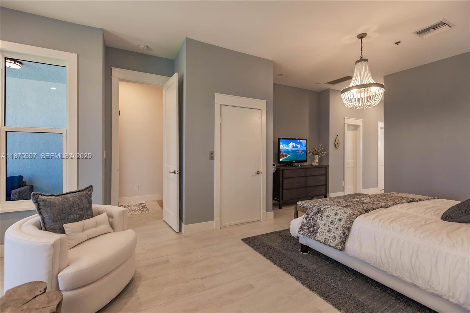 117 Ocean Key Way Jupiter, FL 33477 - Photo 50 of 58 a bedroom with a bed and a chandelier