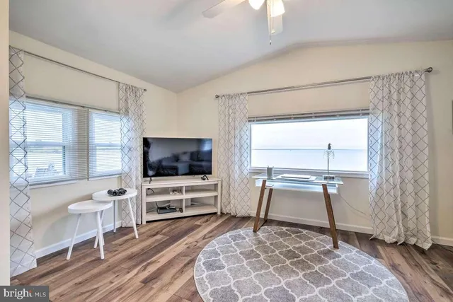 a living room with a flat screen tv a rug and a window