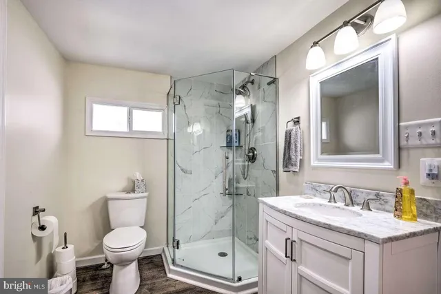a bathroom with a granite countertop sink toilet and shower