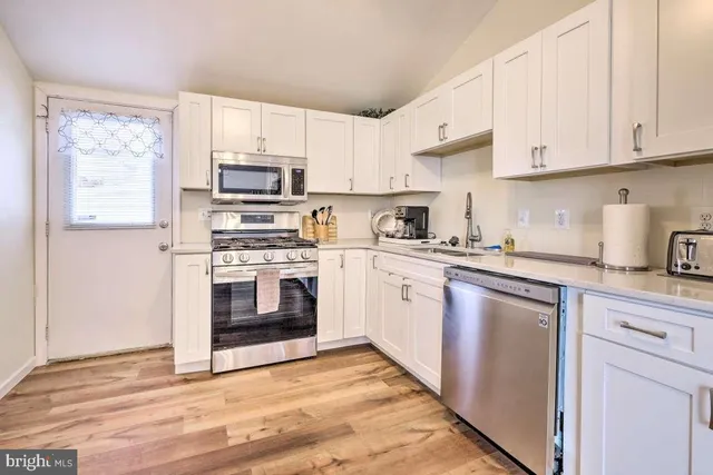 a kitchen with cabinets stainless steel appliances and a sink
