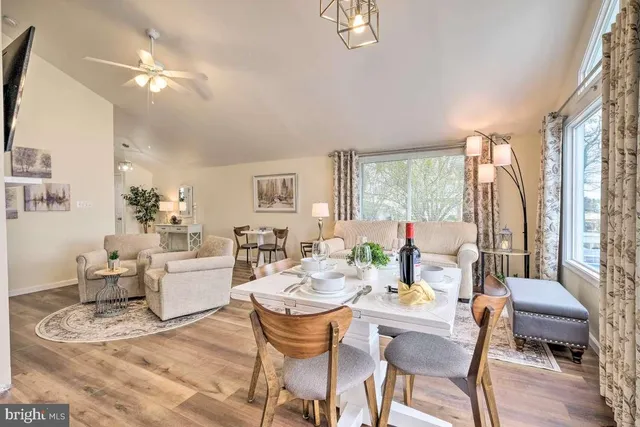 a dining room with furniture a chandelier and wooden floor