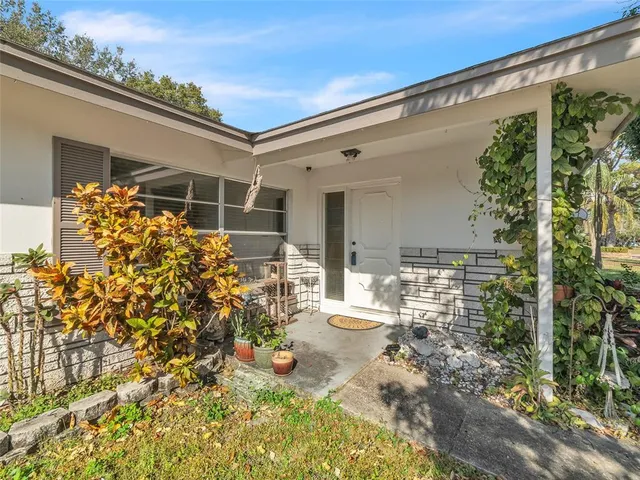 a view of a porch with chairs and potted plants