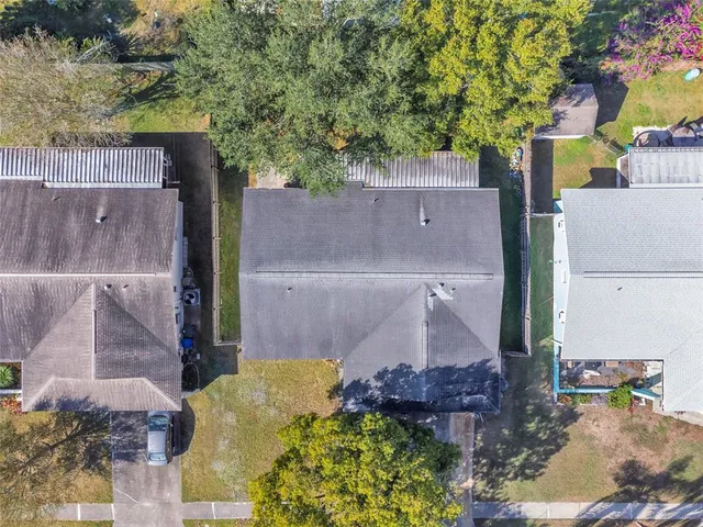 aerial view of a house with a yard and large tree